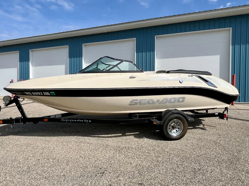 Slide: The Image of 2007 Sea-Doo 205 Utopia boat on trailer, parked outside blue building. - 7