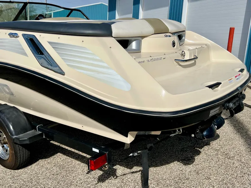 Slide: The Image of 2007 Sea-Doo 205 Utopia boat on trailer, beige and black design, parked outdoors. - 8
