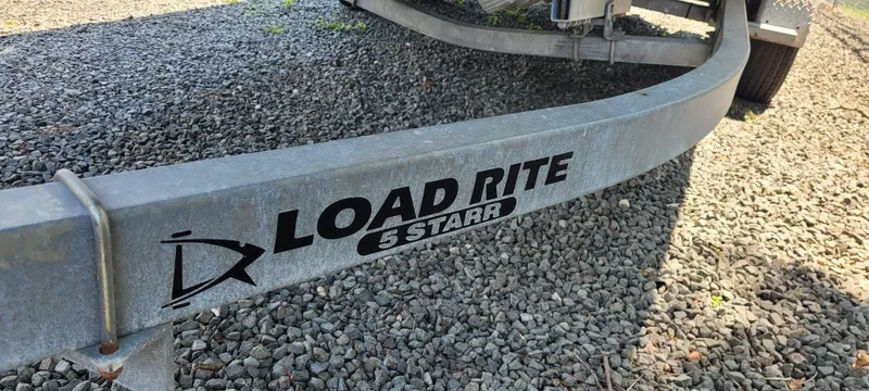 Slide: The Image of Trailer for Boston Whaler 240 Outrage 2000, Load Rite 5 Starr, on gravel surface. - 14