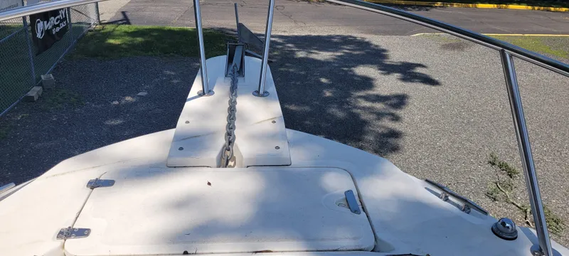 Slide: The Image of Boston Whaler 240 Outrage 2000 boat bow with anchor chain on gravel surface. - 6