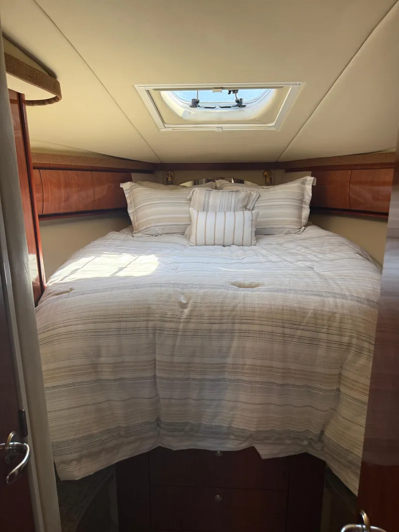 Slide: The Image of Cozy cabin interior of 2003 Sea Ray 420 Sundancer with skylight and striped bedding. - 21