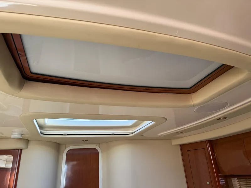 Slide: The Image of Interior view of 2003 Sea Ray 420 Sundancer yacht with skylight and wooden accents. - 24
