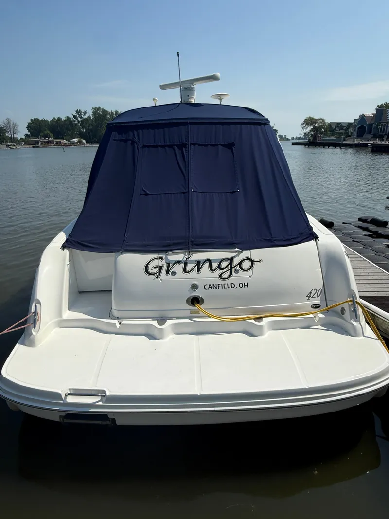 Slide: The Image of 2003 Sea Ray 420 Sundancer docked, rear view with blue cover, named "Gringo." - 3
