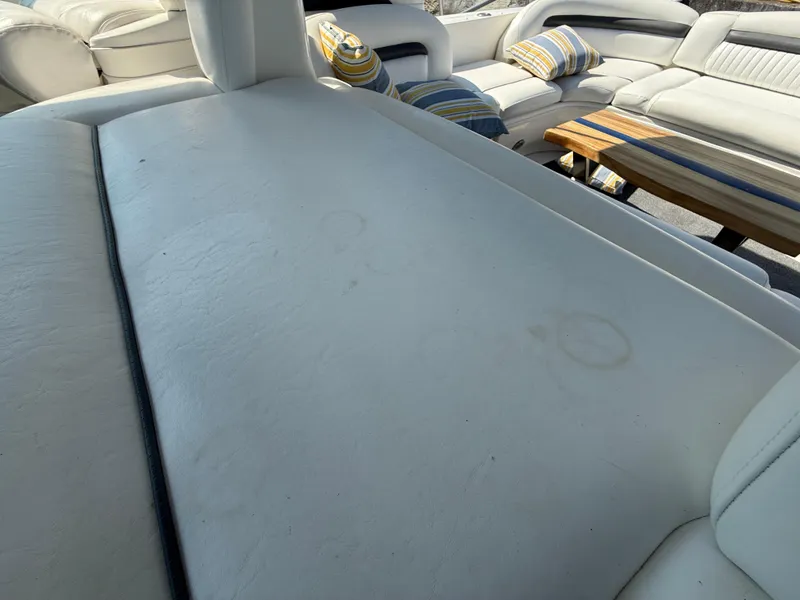 Slide: The Image of 2003 Sea Ray 420 Sundancer interior with white leather seating and striped cushions. - 34