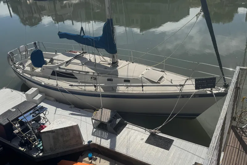 The Image of 1982 O'Day 34 sailboat docked at marina, featuring blue sail cover and sleek design. - 0