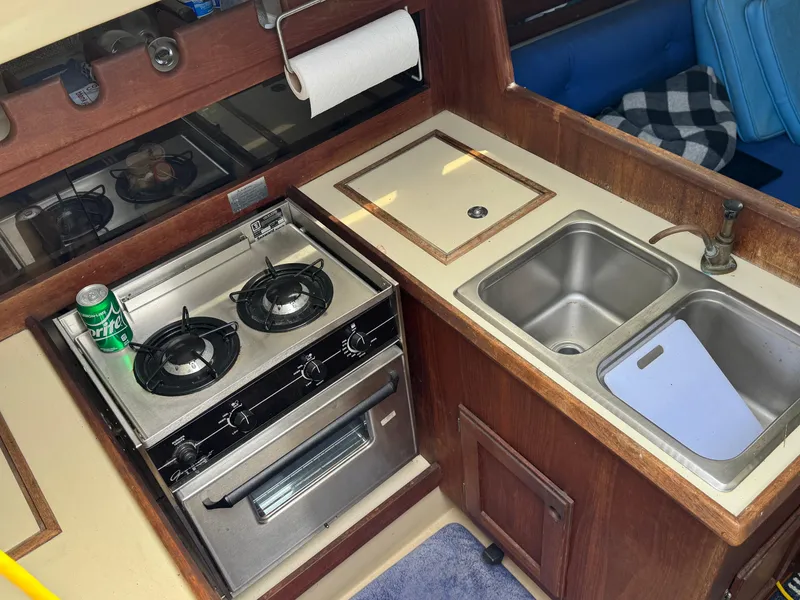 Slide: The Image of 1982 O'Day 34 yacht kitchen with stove, double sink, and wooden cabinetry. - 4