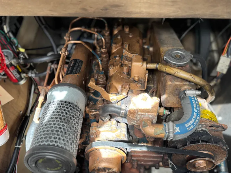 Slide: The Image of Engine of a 1982 O'Day 34 sailboat, showcasing mechanical components and hoses. - 7