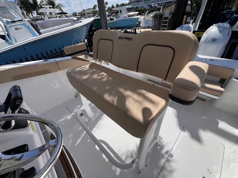 Slide: The Image of 2026 Sea Pro 262 Sport boat with tan seating and steering wheel, docked outdoors. - 14