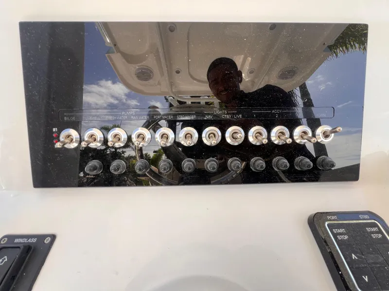 Slide: The Image of Control panel of a 2026 Sea Pro 262 Sport boat with switches and reflections. - 19