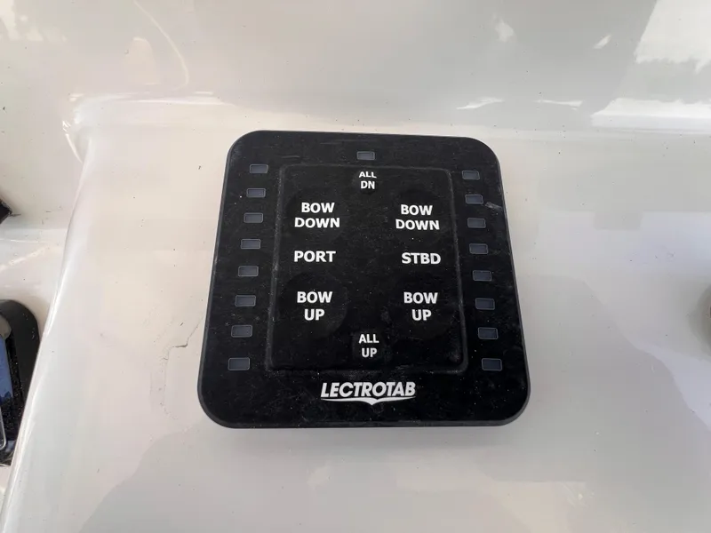 Slide: The Image of Control panel on a 2026 Sea Pro 262 Sport boat with trim tab buttons. - 21