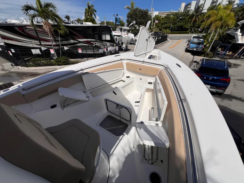 Slide: The Image of 2026 Sea Pro 262 Sport boat interior with seating and storage, parked near RVs and palm trees. - 34