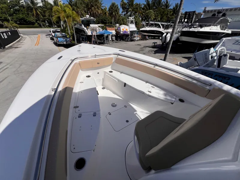 Slide: The Image of 2026 Sea Pro 262 Sport boat interior with seating, docked near other boats. - 36