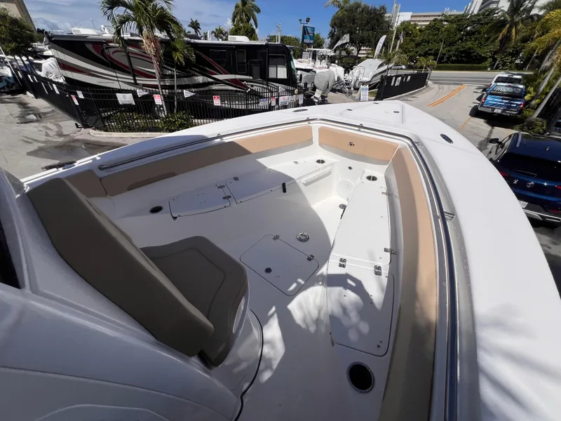 Slide: The Image of 2026 Sea Pro 262 Sport boat interior with seating and storage, docked near palm trees. - 37
