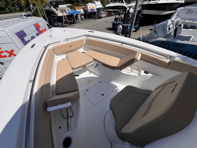 Slide: The Image of 2026 Sea Pro 262 Sport boat interior with beige seating, docked near FedEx van. - 38