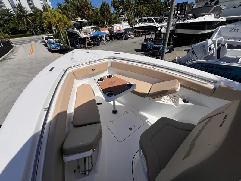 Slide: The Image of 2026 Sea Pro 262 Sport boat interior with seating and table, docked near other boats. - 40