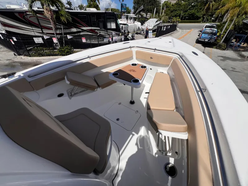 Slide: The Image of 2026 Sea Pro 262 Sport boat interior with seating and table, parked near RVs and palm trees. - 41