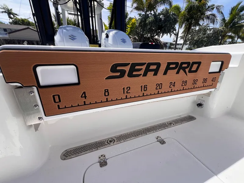 Slide: The Image of 2026 Sea Pro 262 Sport boat with measuring board, palm trees in background. - 48