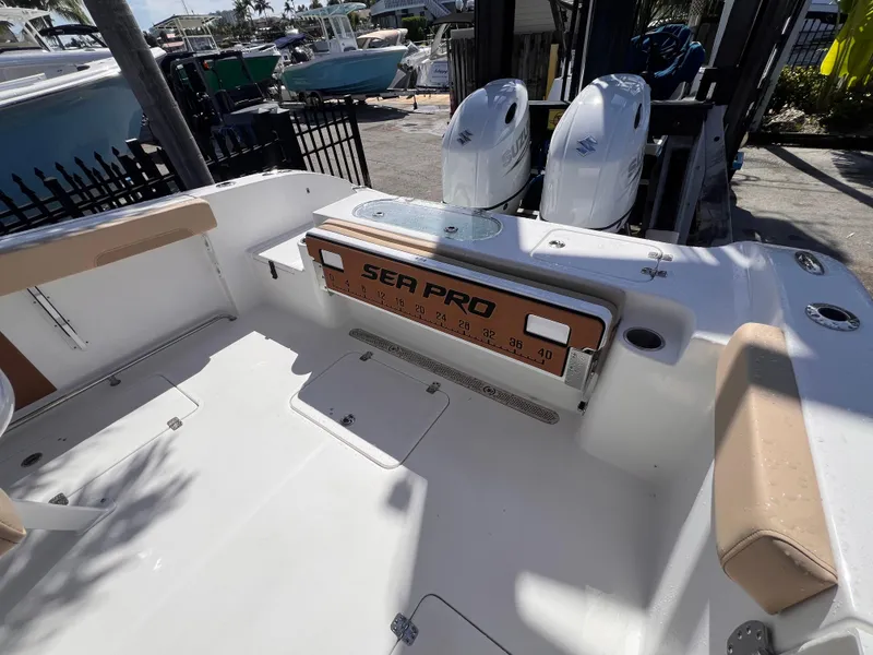 Slide: The Image of 2026 Sea Pro 262 Sport boat interior with dual Suzuki engines, docked outdoors. - 6