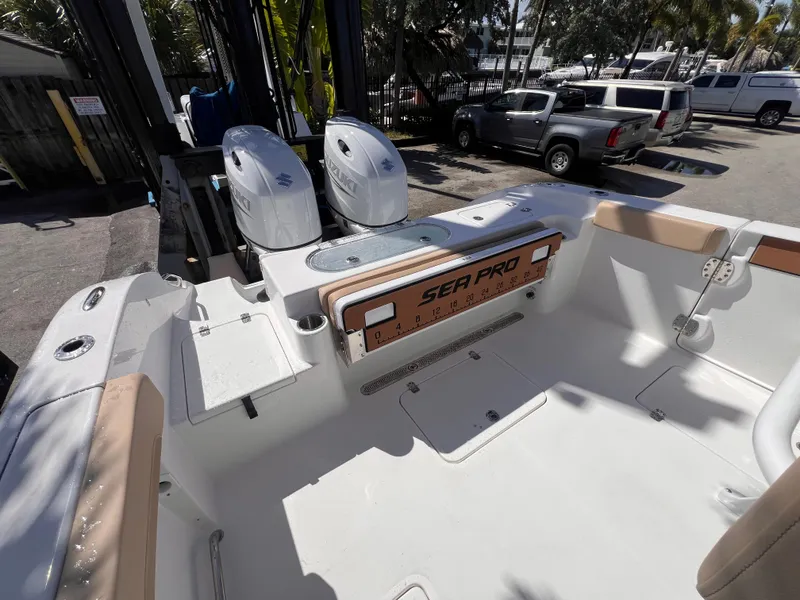 Slide: The Image of 2026 Sea Pro 262 Sport boat interior with dual Suzuki engines, parked outdoors. - 7