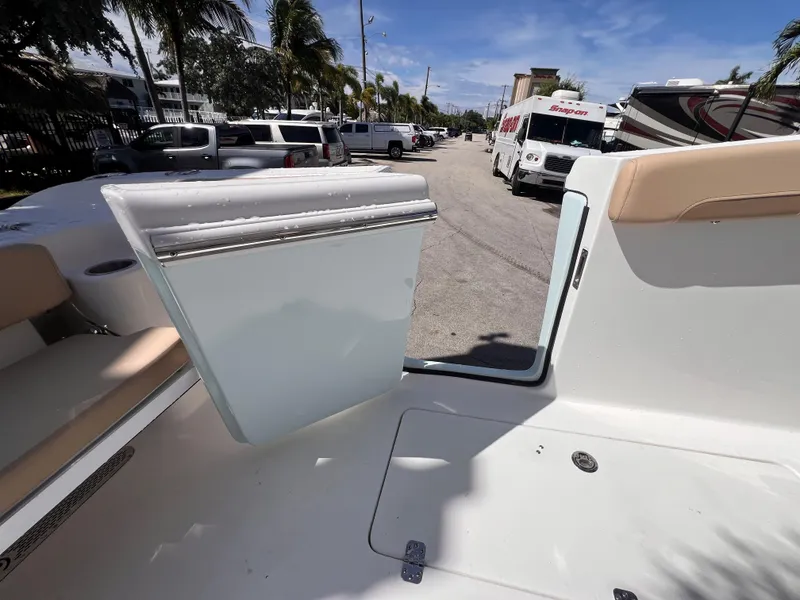 Slide: The Image of 2026 Sea Pro 262 Sport boat interior with open hatch, parked near vehicles. - 8