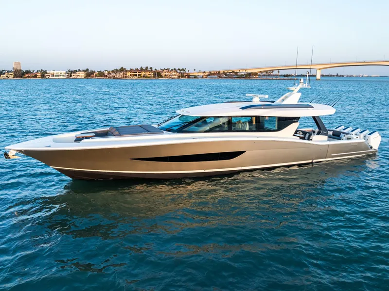 The Image of 2026 Scout 670 LXS luxury yacht cruising on blue water near a bridge. - 0
