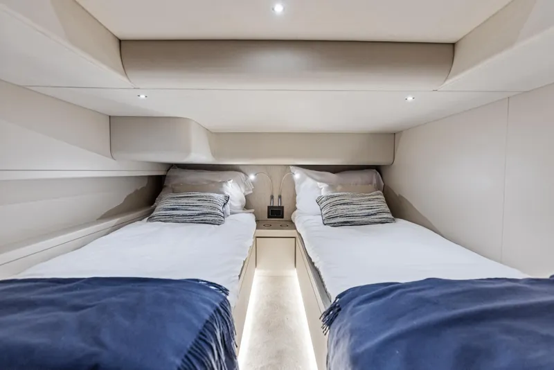 Slide: The Image of Luxurious twin cabin interior of 2026 Scout 670 LXS yacht, featuring modern bedding and ambient lighting. - 39