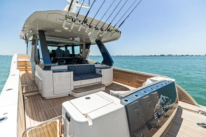 Slide: The Image of Luxurious 2026 Scout 670 LXS yacht with spacious deck and fishing rods, cruising on clear waters. - 8