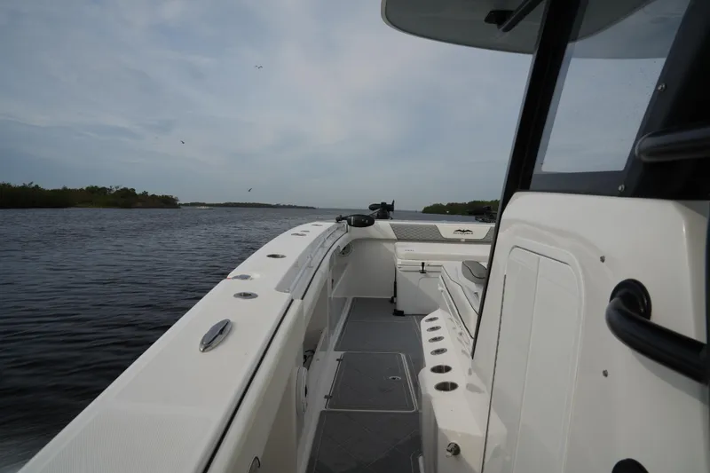 Slide: The Image of 2022 Invincible 46 Catamaran on calm waters, showcasing sleek design and spacious deck. - 12