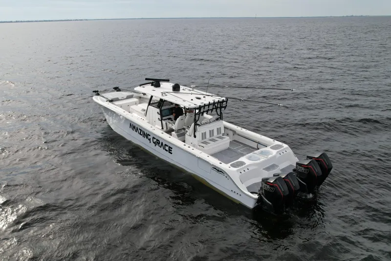 Slide: The Image of Invincible 46 Catamaran 2022 on open water, featuring triple outboard engines. - 6