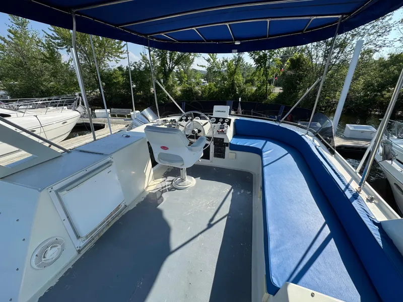 Slide: The Image of 1985 Bluewater Yachts 51 Coastal Cockpit MY with blue seating and canopy, docked outdoors. - 12