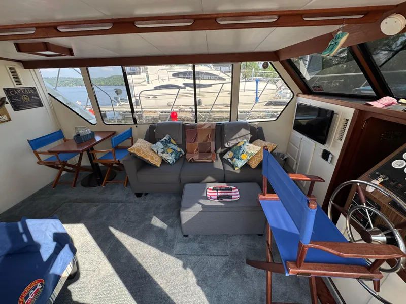 Slide: The Image of Interior of 1985 Bluewater Yachts 51 Coastal Cockpit MY with cozy seating and nautical decor. - 13