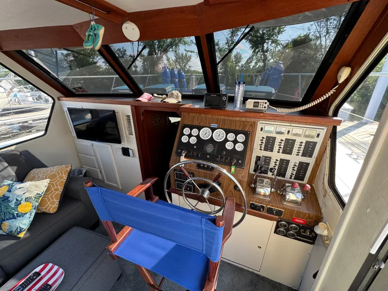 Slide: The Image of 1985 Bluewater Yachts 51 Coastal Cockpit MY helm with controls, gauges, and seating. - 14