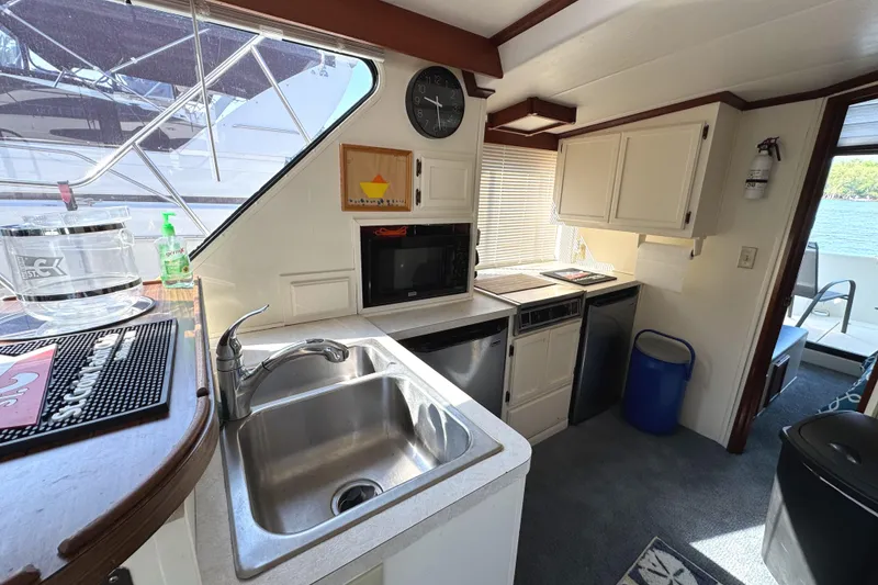 Slide: The Image of 1985 Bluewater Yachts 51 Coastal Cockpit MY kitchen with sink, microwave, and outdoor view. - 16