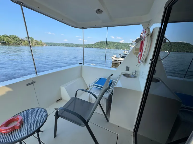 Slide: The Image of 1985 Bluewater Yachts 51 Coastal Cockpit MY, featuring a serene lake view from the deck. - 23