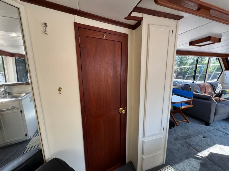 Slide: The Image of Interior of 1985 Bluewater Yachts 51 Coastal Cockpit MY, featuring wood door and cozy seating area. - 25