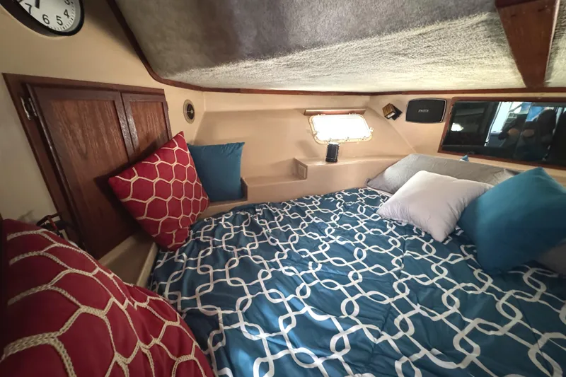 Slide: The Image of Cozy cabin interior of 1985 Bluewater Yachts 51 Coastal Cockpit MY with patterned bedding. - 32