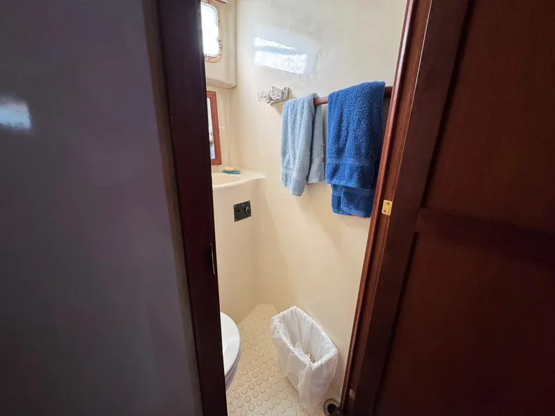 Slide: The Image of 1985 Bluewater Yachts 51 Coastal Cockpit MY bathroom with towels and porthole window. - 35
