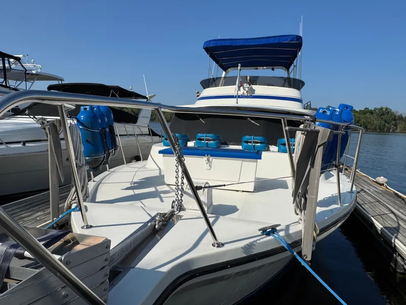 Slide: The Image of 1985 Bluewater Yachts 51 Coastal Cockpit MY docked, featuring blue accents and spacious deck. - 5