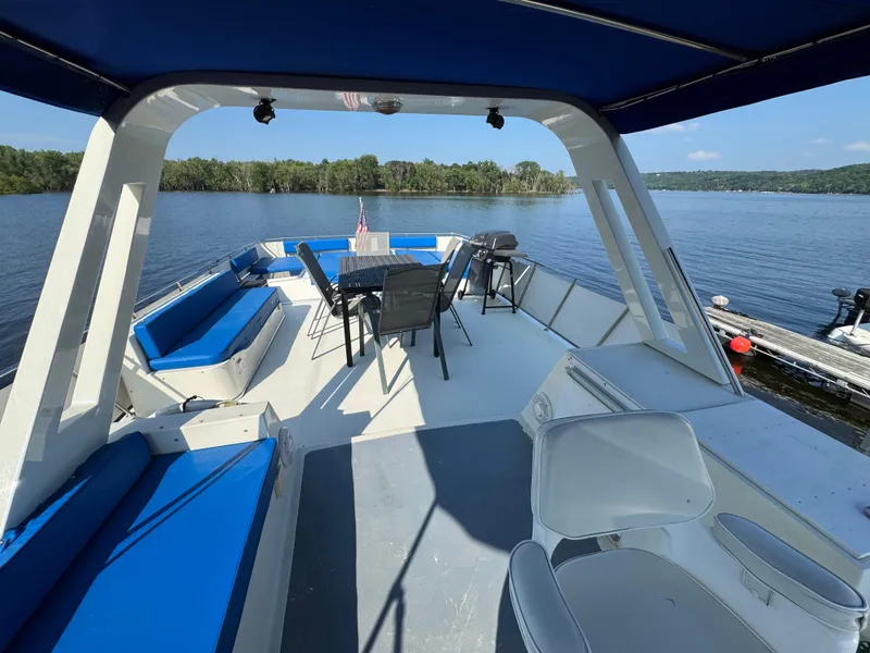 Slide: The Image of 1985 Bluewater Yachts 51 Coastal Cockpit MY with spacious deck and seating, overlooking serene water. - 8