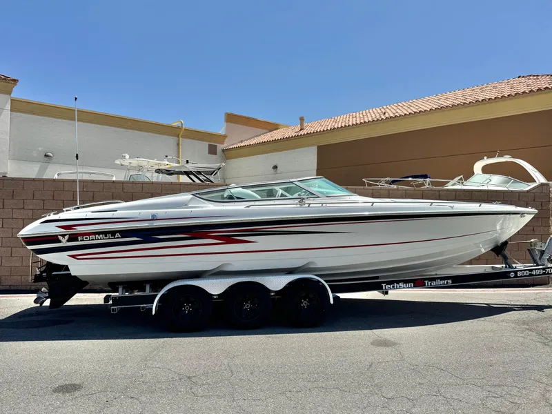 The Image of 2006 Formula 292 boat on trailer, white with red and black accents, parked outdoors. - 0