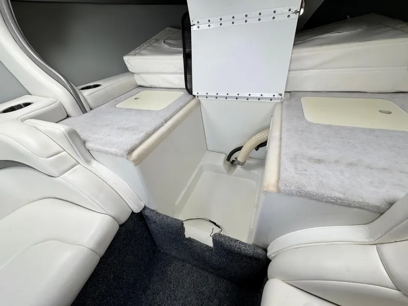Slide: The Image of Interior of a 2006 Formula 292 boat, featuring white seating and storage compartments. - 16