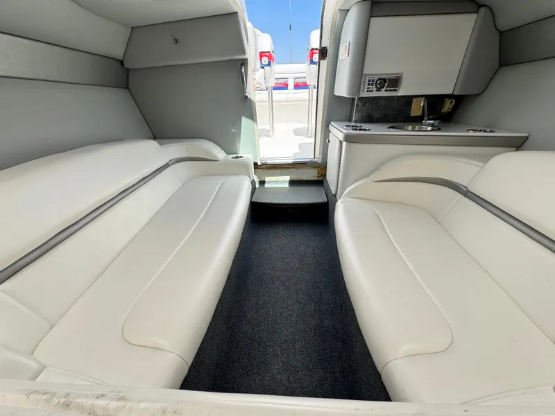 Slide: The Image of Interior of a 2006 Formula 292 boat with white seating and compact kitchenette. - 17
