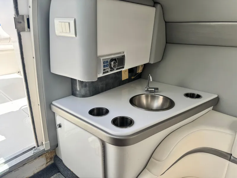 Slide: The Image of Compact boat kitchenette with sink, cup holders, and control panel in a 2006 Formula 292 model. - 18