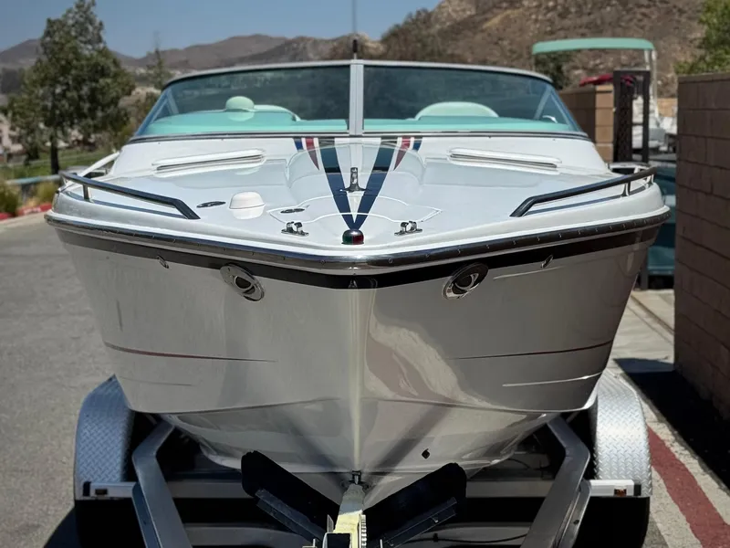 Slide: The Image of 2006 Formula 292 boat on trailer, parked outdoors with scenic mountain background. - 2