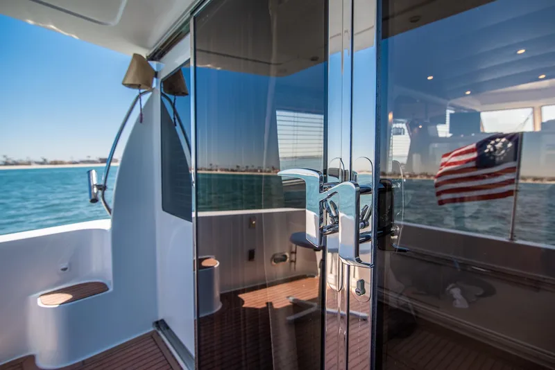Slide: The Image of 2008 Navigator 5100 yacht with glass doors, ocean view, and American flag. - 23
