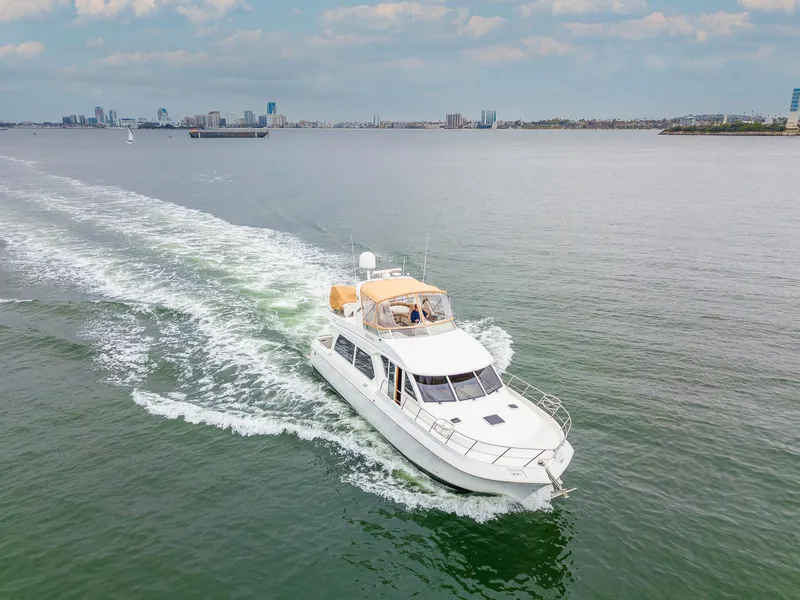 Slide: The Image of 2008 Navigator 5100 yacht cruising on open water with city skyline in background. - 45