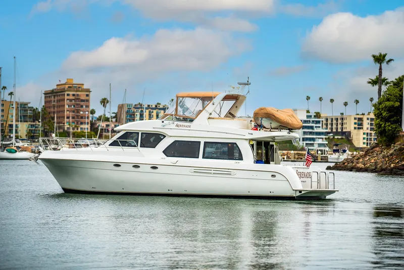 Slide: The Image of 2008 Navigator 5100 yacht cruising in a marina with cityscape background. - 46