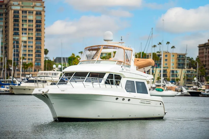 Slide: The Image of 2008 Navigator 5100 yacht docked in marina with cityscape background. - 48