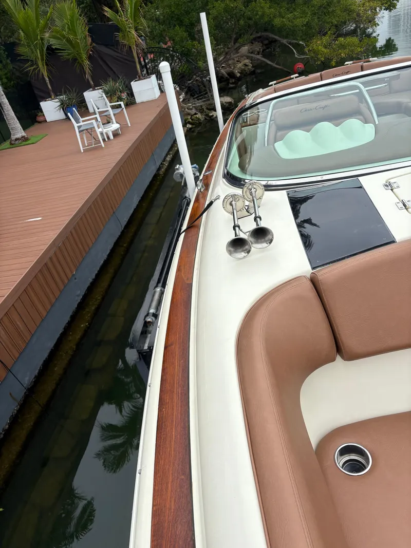 Slide: The Image of 2015 Chris-Craft Launch 32 docked near a wooden deck with outdoor seating. - 10