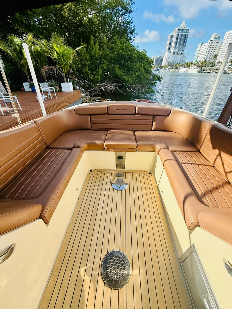 Slide: The Image of 2015 Chris-Craft Launch 32 boat interior with brown leather seating and wooden deck. - 19